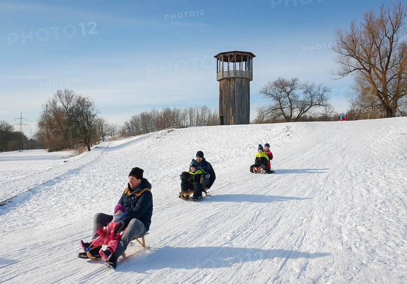Recklinghausen, North Rhine-Westphalia, Germany - Sunny winter landscape in the Ruhr area, Emscher art in the snow, Kawamata Tower on the Emscher, WALKWAY AND TOWER, 2010, by Tadashi Kawamata, Families go sledging