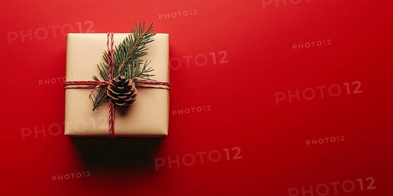 Banner with small Christmas gift box wrapped in graft paper on red background with copy space. Generative Ai, AI generated