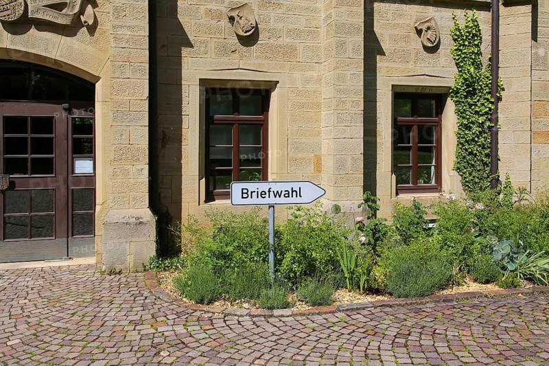 Postal voting sign, signpost for postal voting, writing, letters, information board, behind Varbülersches Schloss, Schloss Hemmingen, former seat of the barons of Varnbüler, main building today town hall, Hemmingen, Ludwigsburg district, Baden-Württemberg, Germany, Europe