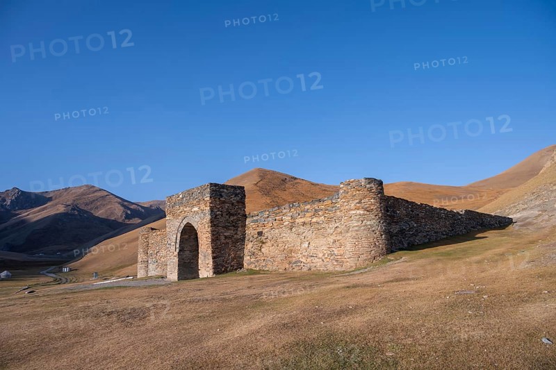 Historic caravanserai Tash Rabat from the 15th century, with yellow hills, Atbashy district in the Naryn region, Kyrgyzstan, Asia