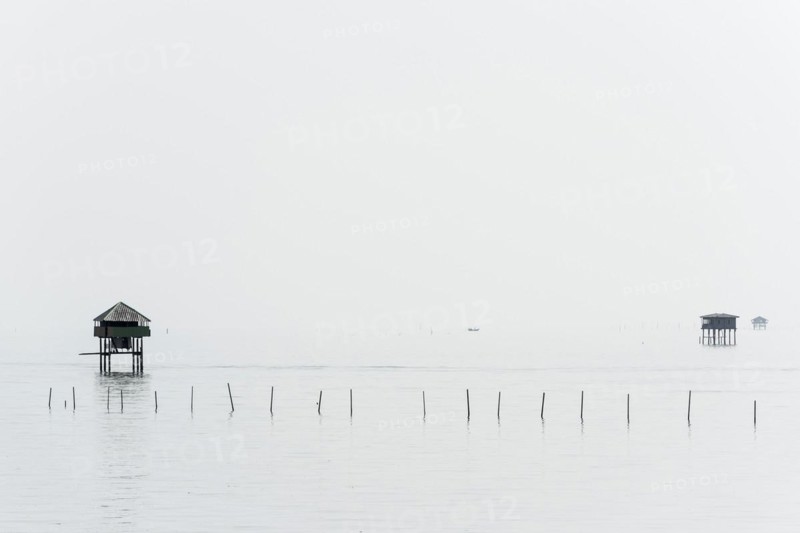 Traditional wooden huts of fishermen in the Gulf of Thailand in the morning haze, fisherman, fisherman's hut, wooden hut, landscape, southern Thailand, seascape, silhouette, nature, stilt hut, stilt buildings, tradition, traditional, fishing village, water, ocean, calm, work, romantic, monochrome house, accommodation, natural landscape, travel, holiday, coast, hazy, haze, foggy, mist, tropical, tropics, tourism, cloudy, weather, mood, grey, puristic, visibility, distance, far, Thailand, Asia