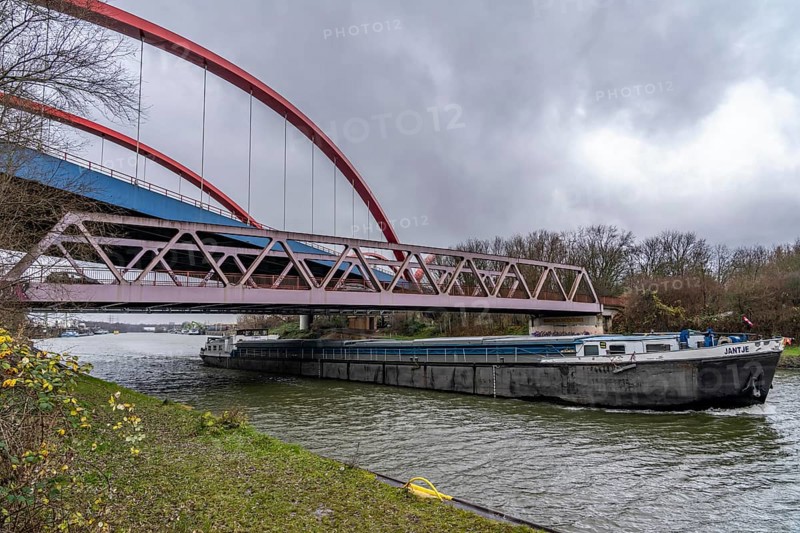 Freighter, dilapidated motorway bridge A42, (red arches) over the Rhine-Herne Canal, with massive structural damage, totally closed for the next few months, between the Bottrop-Süd and Essen-Nord junctions, for trucks probably until a new bridge is built, North Rhine-Westphalia, Germany, Europe