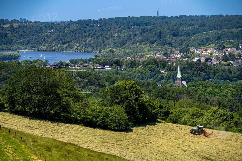 Lake Baldeney in Essen, view to the west, over the district of Kupferdreh, from Velbert, farmer turning freshly cut hay, North Rhine-Westphalia, Germany, Europe