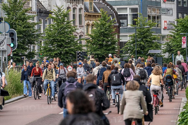 Central cycle path on Smakkelaarskade, at Utrecht Centraall station, in the centre of Utrecht, lanes for pedestrians, cyclists and cars are separated, waiting at traffic lights, heavy traffic, Netherlands