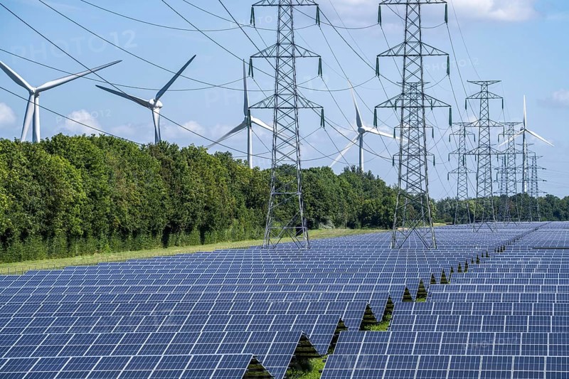 High-voltage power line route, the space underneath is used for a solar park over 5 km long, behind it a wind farm, in the harbour area of Vlissingen-Oost, Netherlands