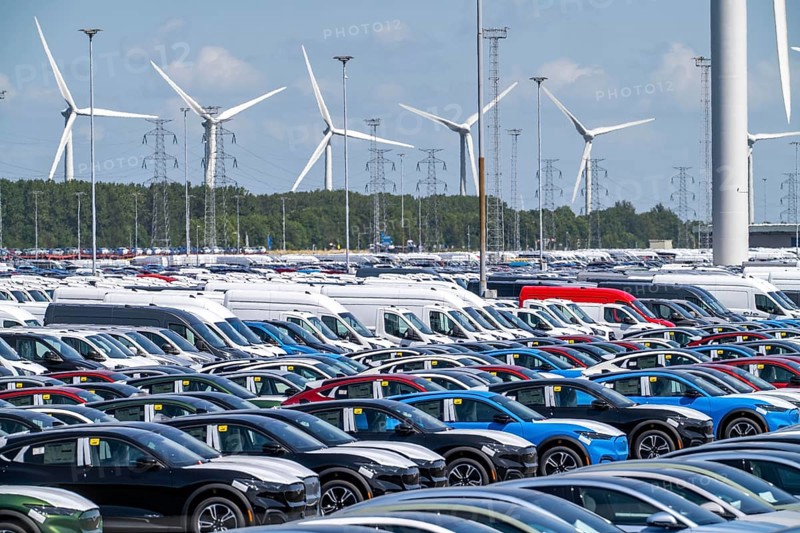 Storage area for new cars in the port of Vlissingen-Oost, vehicles are temporarily stored on over 100 hectares to ship them from Europe to the United Kingdom, Ford cars, others such as models from the Chinese car manufacturer BYD are delivered from here in Europe, wind farm, Netherlands