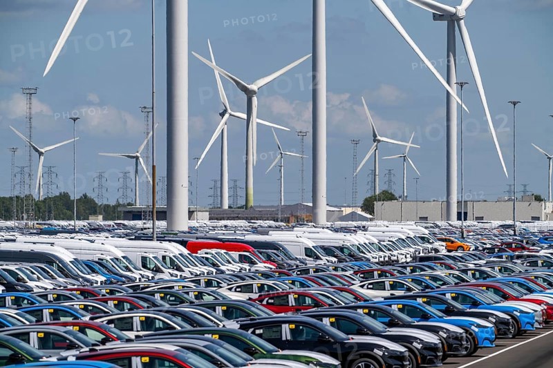 Storage area for new cars in the port of Vlissingen-Oost, vehicles are temporarily stored on over 100 hectares to ship them from Europe to the United Kingdom, Ford cars, others such as models from the Chinese car manufacturer BYD are delivered from here in Europe, wind farm, Netherlands