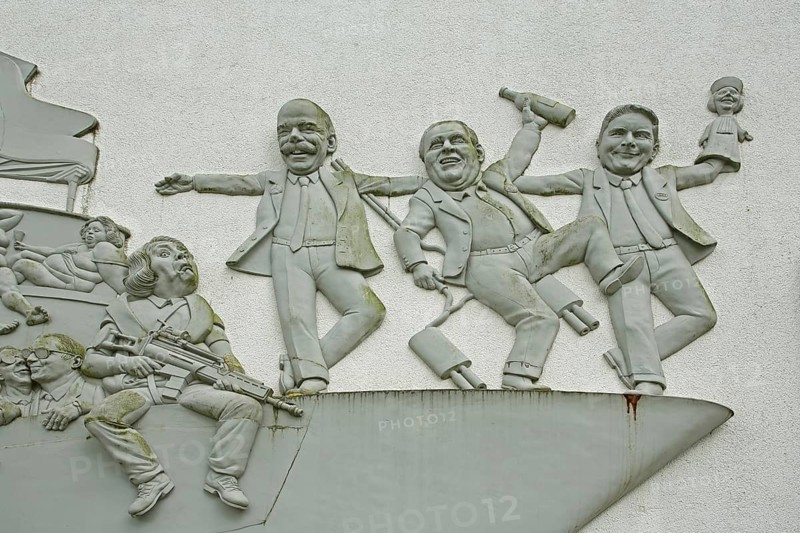 Sculpture Ship of Fools by Peter Lenk 2003, manager automotive industry, Dieter Zetsche, Martin Winterkorn, Rupert Stadler, satire, joy, celebrate, dance, irony, figures, monochrome, grey, relief, house wall, detail, Seeum, Bodman, Bodman-Ludwigshafen, Überlinger See, Lake Constance, Lake Constance area, Hegau, Baden-Württemberg, Germany, Europe