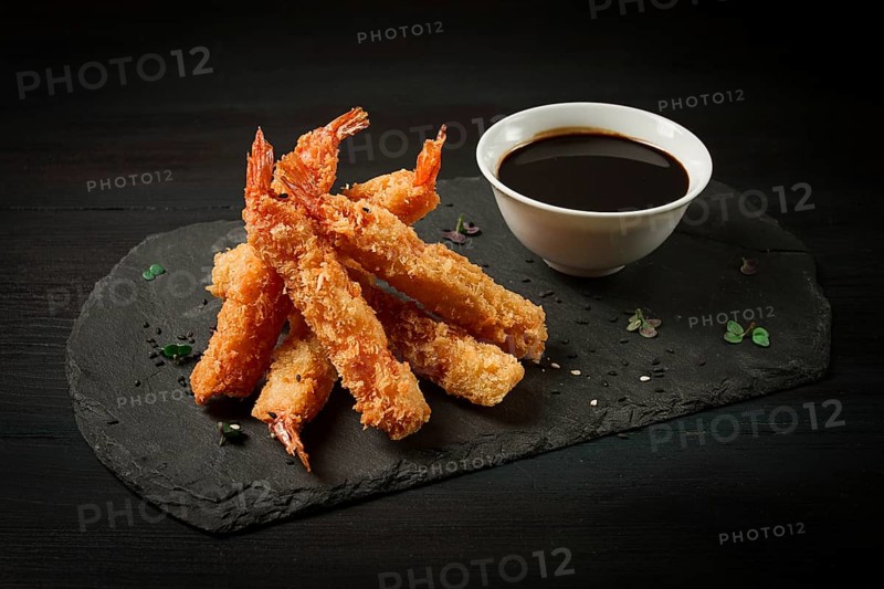 Shrimp in tempura, deep-fried, on black slate, with soy sauce, horizontal, no people