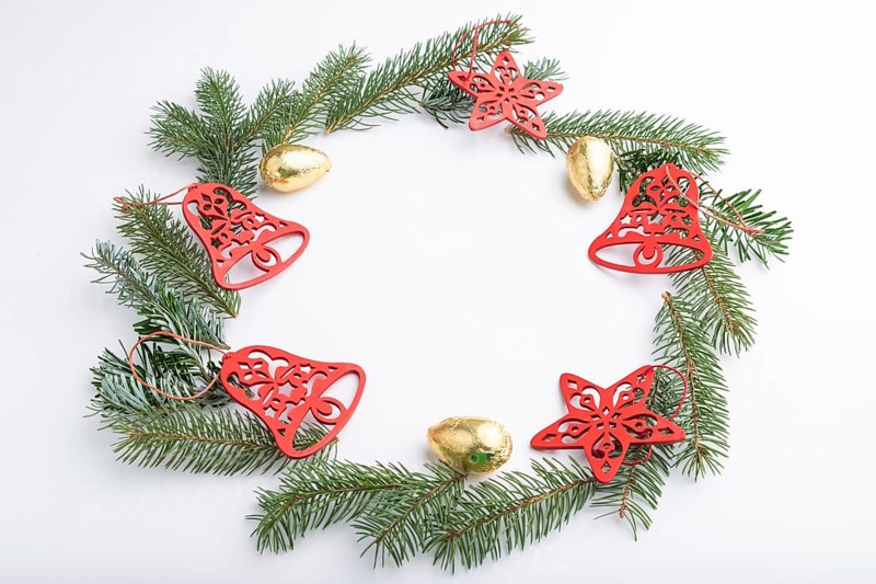Christmas or New Year wreath composition. Decorations, stars, bells, fir and spruce branches, on white background. Side view, copy space