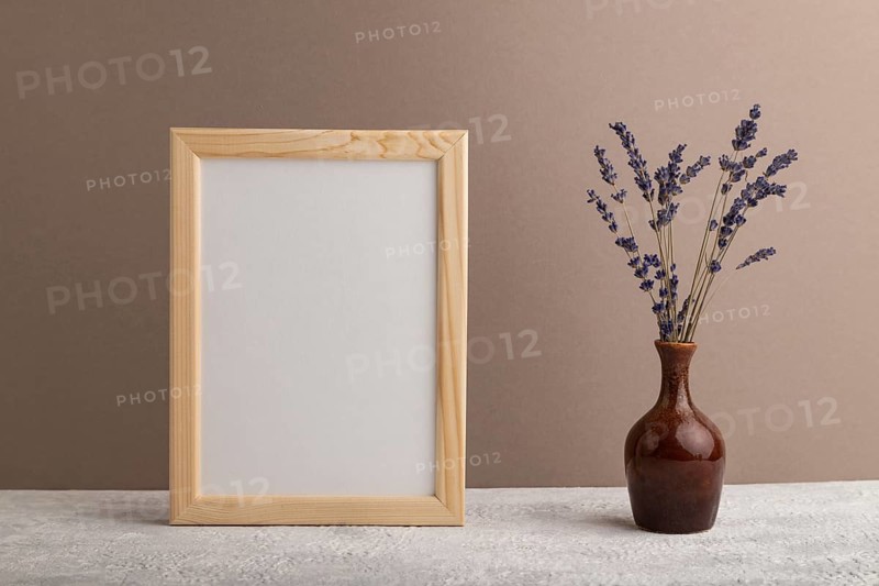 White wooden frame mockup with lavender in ceramic vase on beige paper background. Blank, vertical orientation, still life, copy space