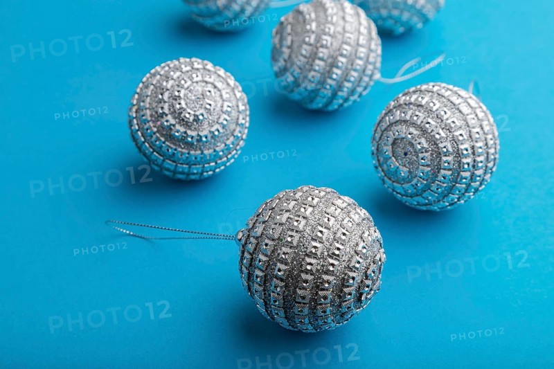 Christmas or New Year composition. Decorations, silver balls, on a blue paper background. Side view, close up