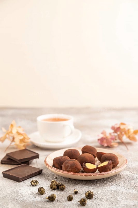 Japanese rice sweet buns chocolate mochi filled with cream and cup of green tea on brown concrete background. side view, close up, selective focus