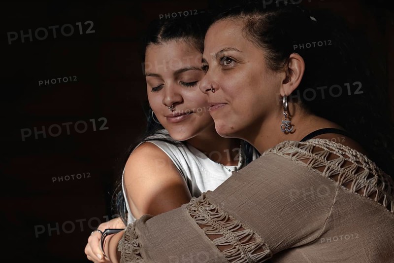 Portrait of deaf Latina mother hugging with young adult daughter