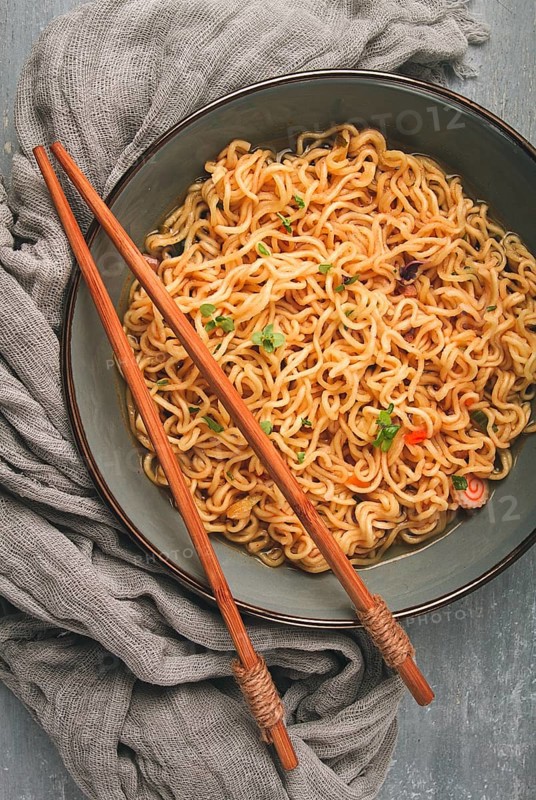 Instant noodles, in a bowl, on a gray table, top view, no people