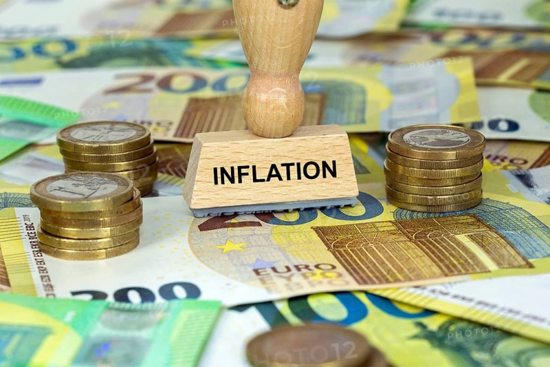 Symbolic image of inflation: stamp with the inscription Inflation on euro banknotes