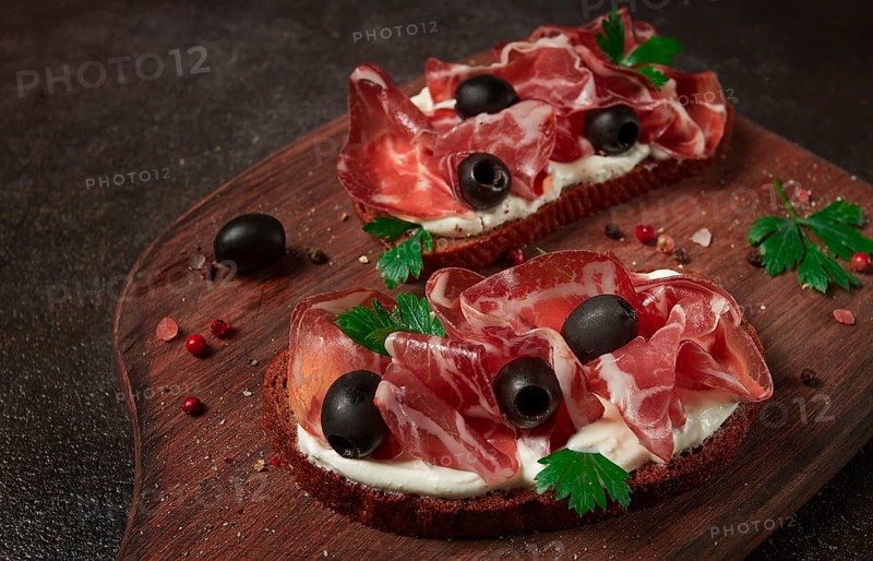 Sandwich with cream cheese, prosciutto with olives, breakfast