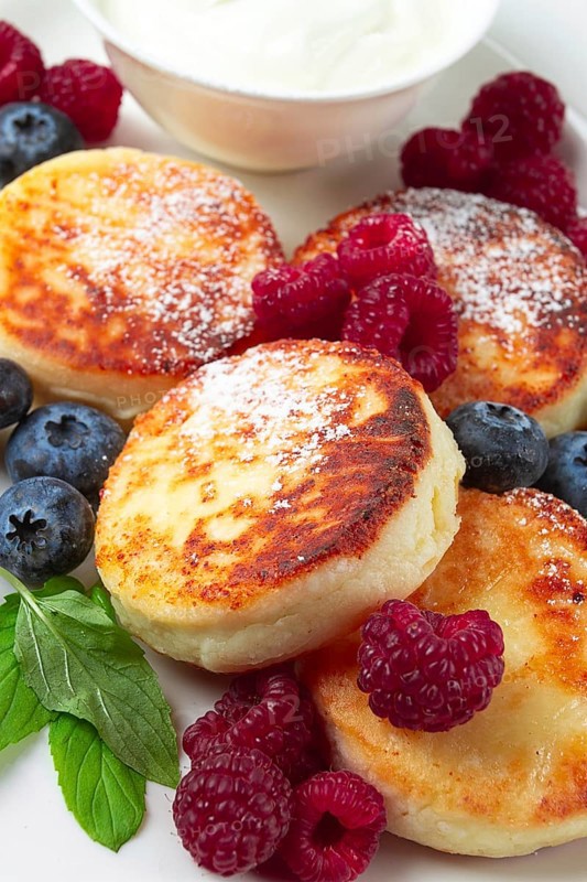 Breakfast, cottage cheese cakes, with fresh berries, and sour cream, top view, close-up, no people