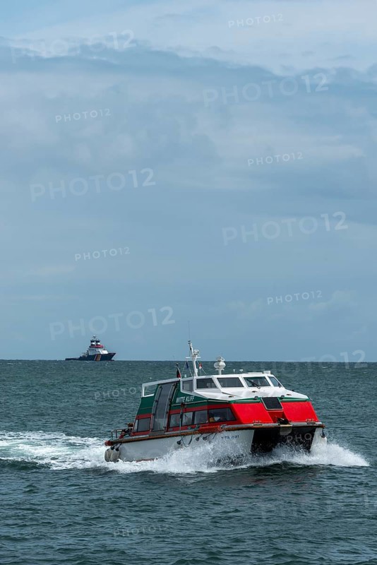 Dune ferry full speed ahead to the offshore island of Helgoland, tugboat on the horizon, North Sea, Pinneberg district, Schleswig-Holstein, Germany, Europe