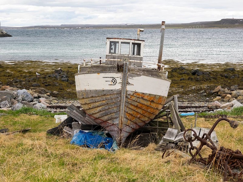 Derelict fishing boat on the shore of the Arctic Ocean, at the edge of the fishing village of Ekkeroy, May, Varangerfjord, Norway, Europe