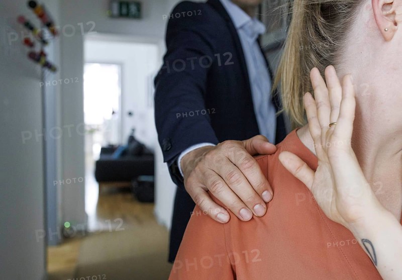 Harassment in the workplace. A man puts his hand on the shoulder of a woman in an office in Berlin, 09/08/2024