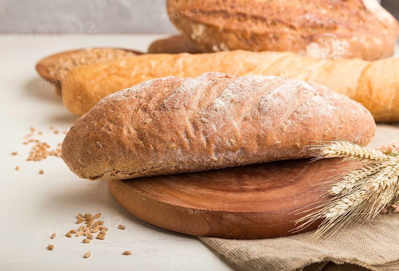 Different kinds of fresh baked bread on a white wooden background. side view, close up, selective focus
