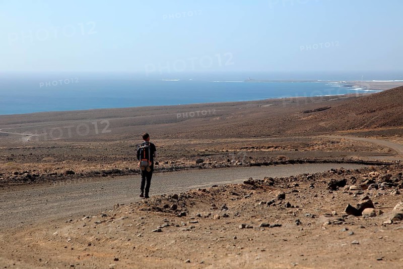 Lone man walking in barren landscape Jandia peninsula, Fuerteventura, Canary Islands, Spain, Europe