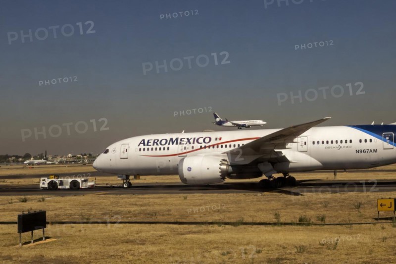 Mexico City, An AeroMexico Boeing 787-8 Dreamliner sits on the tarmac while another AeroMexico flight lands on a nearby runway