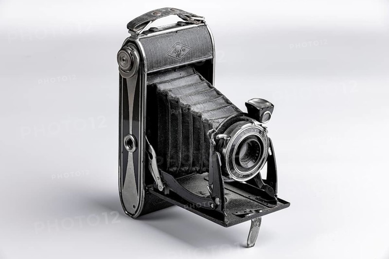 Black bellows camera unfolded on a white background