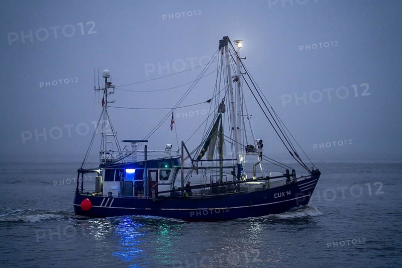 Thick fog in winter, hangs over the mouth of the Elbe into the North Sea, fishing boat, shrimp cutter, SAPHIR, CUX14, enters the harbour of Cuxhaven at dusk, Lower Saxony, Germany, Europe