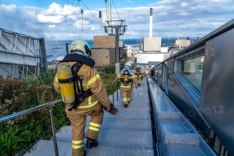 CopenHill, waste incineration plant and artificial ski slope, firefighters under respiratory protection, endurance training, skiing with a view of the ski lift, 90 metres high and 400 metres long slope on artificial turf, Copenhagen, Denmark, Europe
