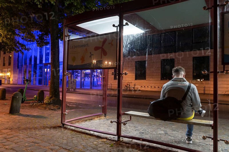 Bus stop, blue illuminated building of the Münster district government, illuminated barrier, in Münster, North Rhine-Westphalia, Germany, Europe