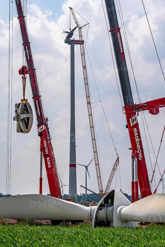 Dismantling of a wind power plant in a wind farm near Issum, 9 older wind turbines from the manufacturer Enercon (model series E-58), front, were in operation for over two decades, will be replaced by a total of four Enercon E-160 turbines, rear, assembly of the first blade, with a total output of 22 megawatts, Lower Rhine, North Rhine-Westphalia, Germany, Europe
