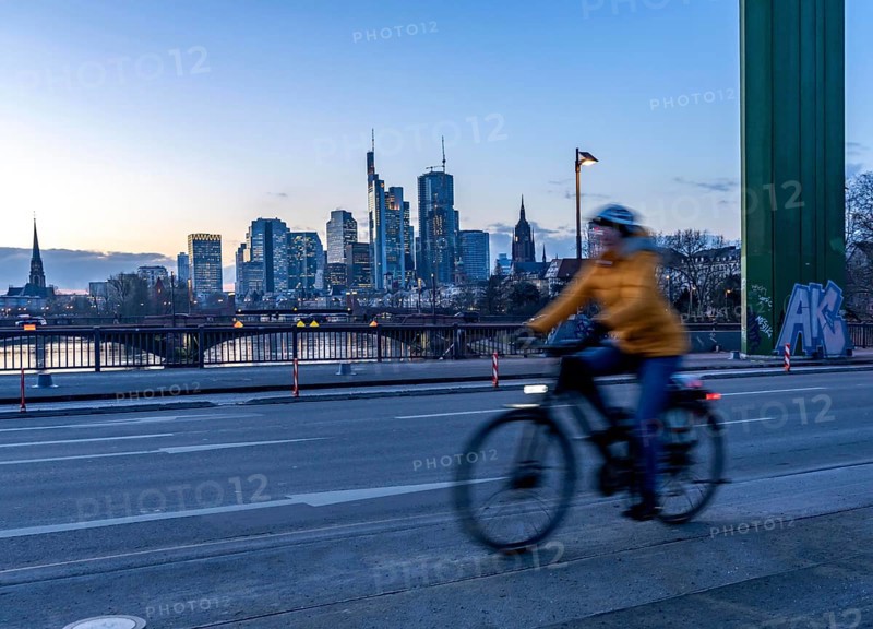 Skyline of the city centre of Frankfurt am Main, cyclist on the raft bridge, dusk, river Main, winter, Hesse, Germany, Europe