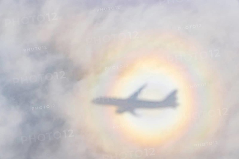 An aeroplane casts a shadow on a cloud, silhouette, halo rainbow. Germany