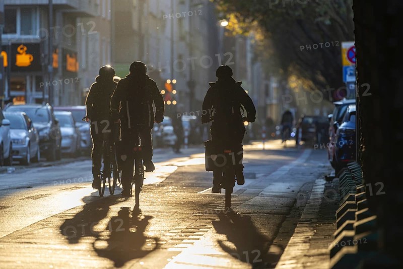 Cyclists in oblique sunlight in November, poor visibility, danger of glare, cycle lane, cyclists have priority over motor traffic, Cologne, North Rhine-Westphalia, Germany, Europe