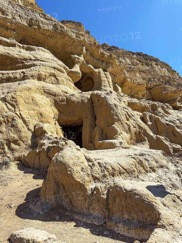 Partial view of former Roman necropolis with sandstone caves carved into sandstone Cave tombs Grottoes in rocks on the north side of Matala Bay, in the 60s and 70s hippie caves Caves for dropouts and hippies today excursion destination on the south coast of Crete island, Matala, Crete, Greece, Europe