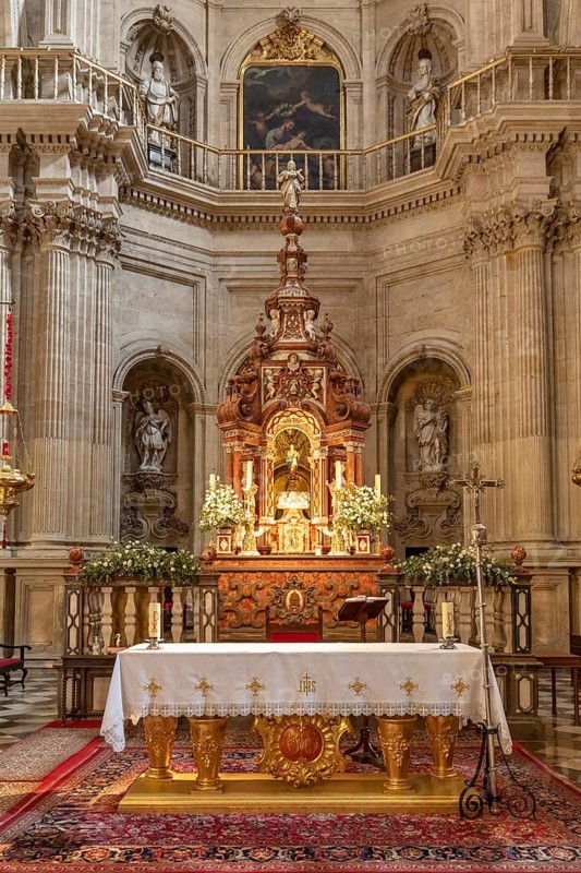 Artistic baroque altar in a church with candles and religious motifs, Granada