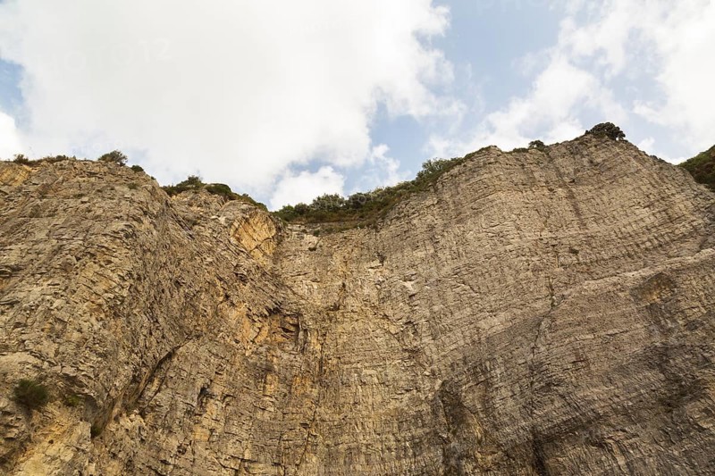 Low angle view of rugged and steep cliff with cut rock face, Sorrento, Campania region, Italy, Europe