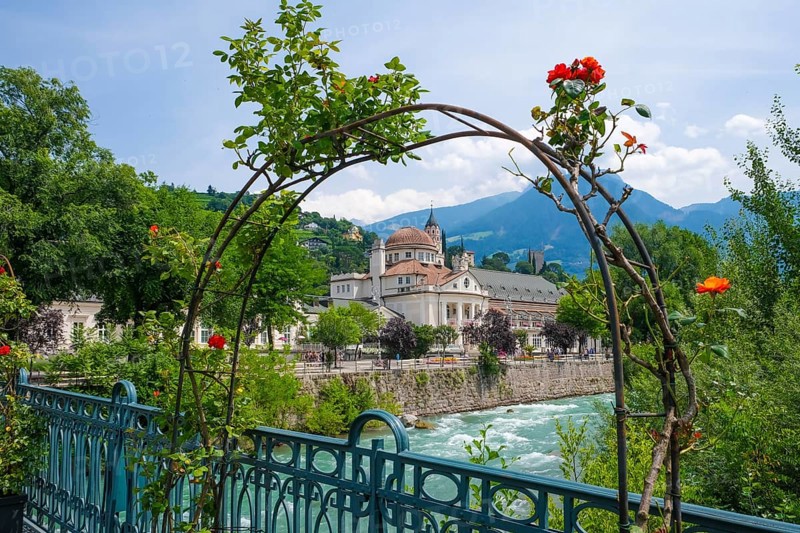Merano, South Tyrol, Italy, spa hotel on the river Passer, on the Passer promenade in the old town centre. Red roses in front on the thermal bridge, Europe