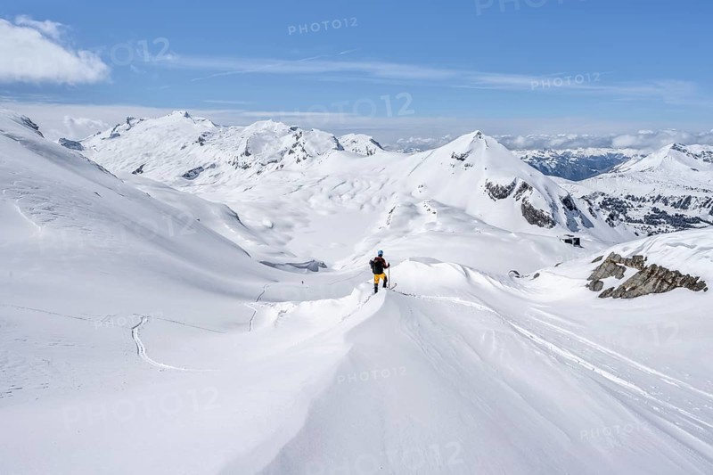 Lone ski tourer in mountain landscape with snow, behind summit Mittaghorn and Wildhorn, ascent to Wildstrubelhütte, Bernese Alps, Switzerland, Europe