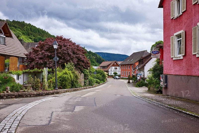 Multi-family houses, lantern, hilly landscape with forest, tavern Am Dorfbach, overcast sky with nimbostratus clouds, sunlight, Bollenbacher Straße, Haslach im Kinzigtal, Black Forest, Ortenaukreis, Baden-Württemberg, Germany, Europe