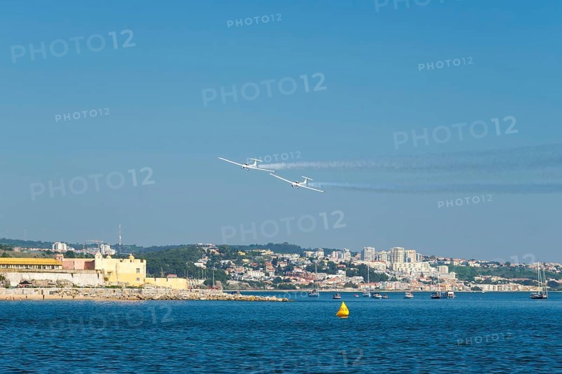 Stunt aerobatic plane performing stunts in blue sky with smoke trail. Concept of teamwork, collaboration, coordination, trust, precision, difficulty, challenge, speed, synergy