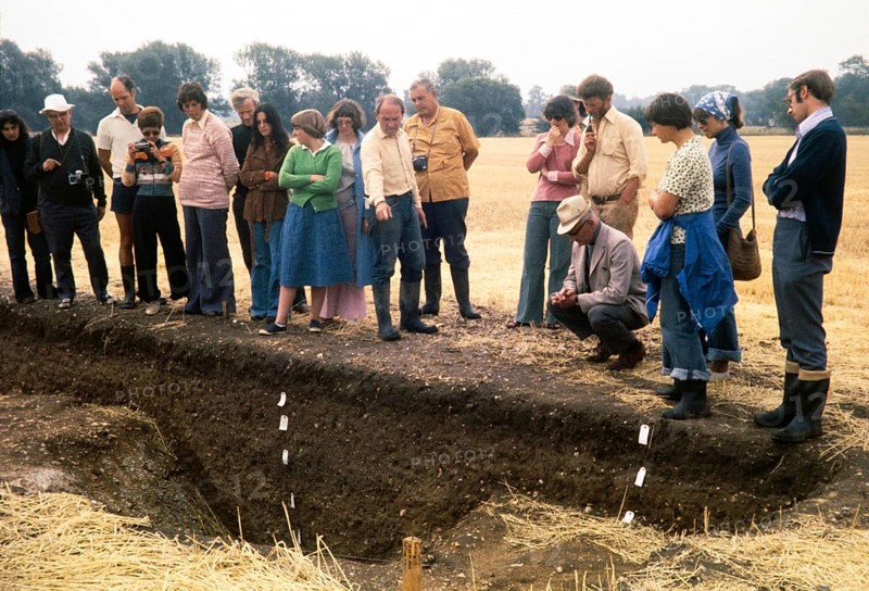 People looking at a trench at the University of Cambridge archaeological site called Great Shelford, Cambridgeshire, England, UK 1976