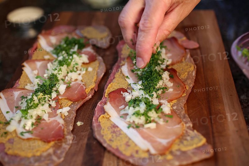 Swabian cuisine, preparation of beef roulade with pine nuts, meat dish, raw beef with Black Forest ham, smoked ham topped with onions and herbs, mustard, main course, roulades on wooden board, grandmother's kitchen, regional, home cooking, typical Swabian, traditional cuisine reinterpreted, men's hands, food photography, studio, Germany, Europe