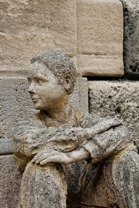 Sculpture in front of the old school building, art in public space, stone figure, sculpture by the artist Ulla Frenger, depiction of a pupil, building from 1867 made of Gönningen tuff, former elementary and secondary school, today the Gönningen branch of the town library, Gönningen, Reutlingen district, Baden-Württemberg, Germany, Europe