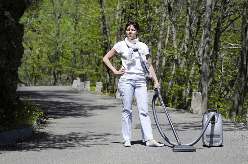 Elegant Woman with a Vacuum Cleaner on the Forest Street in a Sunny Day in Ascona, Ticino, Switzerland, Europe