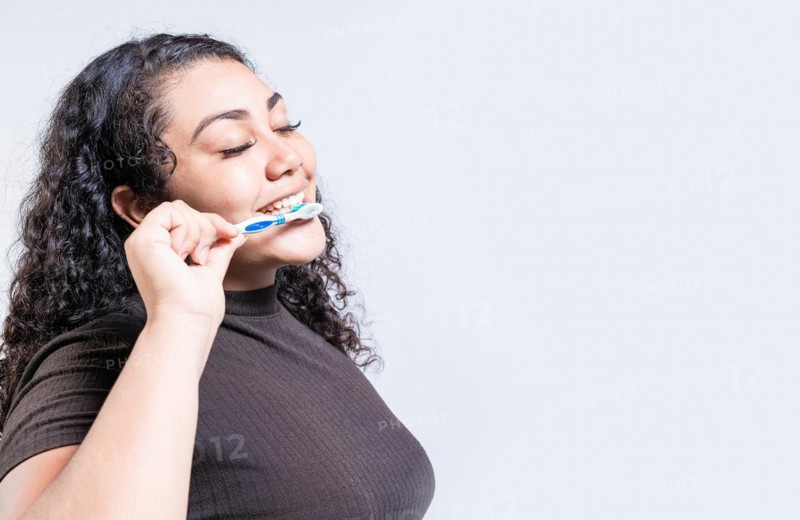 Face of young woman brushing teeth isolated. Oral and dental smile concept. Smiling woman brushing his teeth isolated with copy space