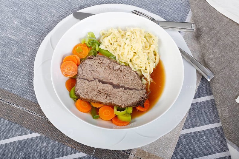Swabian cuisine, roast beef, roast ox, herb spaetzle, meat dish, gravy, carrot vegetables, leek, plate, hearty, savoury, typical Swabian, home cooking, traditional cuisine, food photography, studio, Germany, Europe