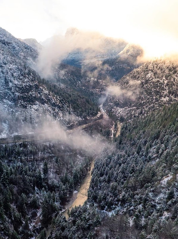 A valley with a river flowing through it surrounded by snow-covered mountains and wafts of mist, Alpenstraße, Bad Reichenhall, Germany, Europe